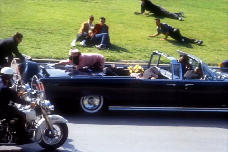 Ngày 22/11/1963, Tổng thống Mỹ John F. Kennedy bị ám sát. Đây là một trong những hình ảnh Tổng thống Kennedy bị bắn khi chiếc xe đi qua kho sách thư viện Texas. Ông đổ người về phía bà Jacqueline, sau khi trúng đạn vào đầu. Sau đó, nhân viên đặc vụ Clinton Hill nhảy lên chiếc xe limousine chở Tổng thống Kennedy và phu nhân để che cho hai người. Đây là một trong những bức ảnh ghi lại sự kiện kinh hoàng xảy ra trong lịch sử.