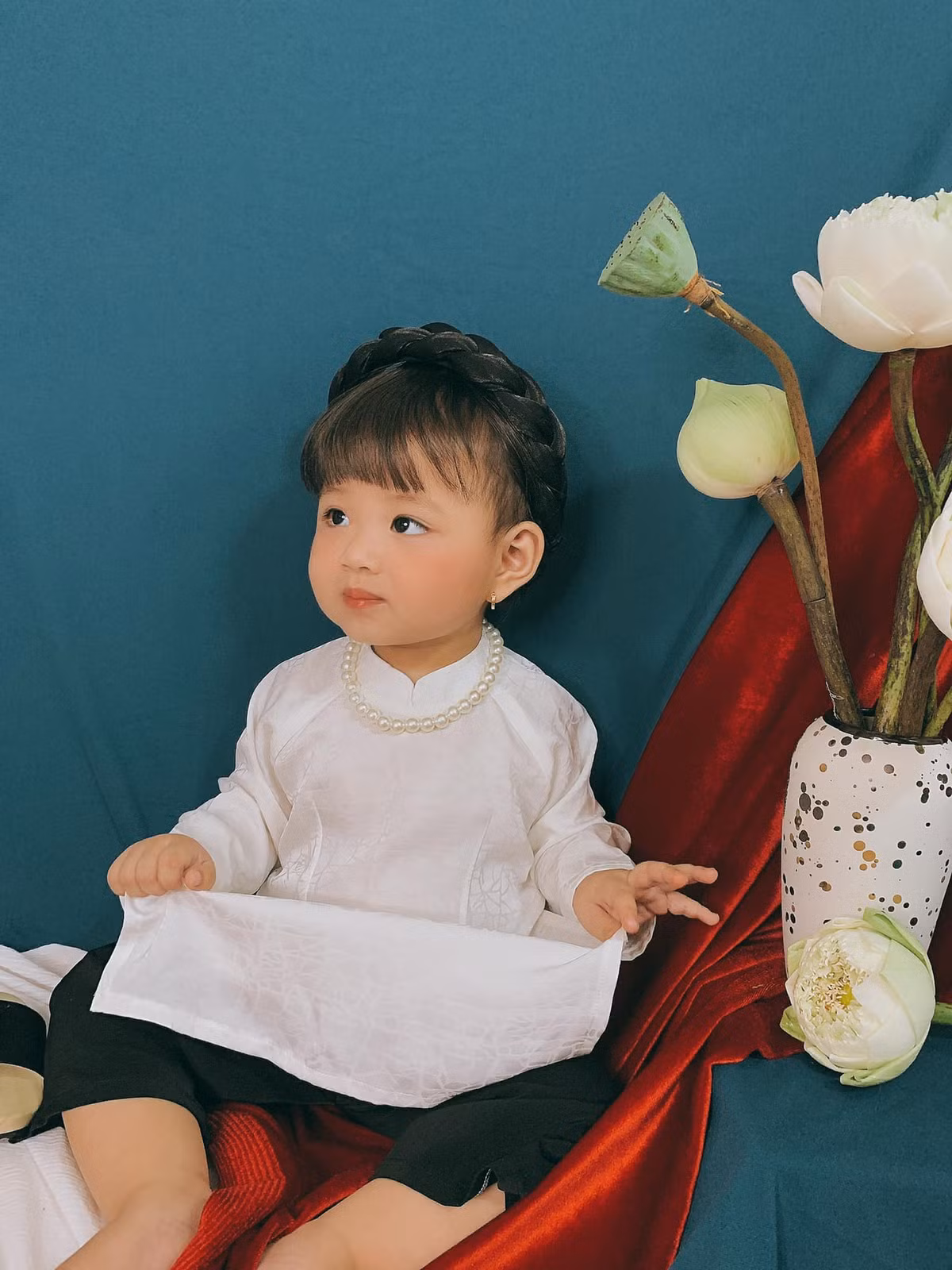 Bé gái trong bộ ảnh Tết dưới đây cũng không ngoại lệ khi được mẹ cho diện áo dài và mấn đội đầu, guốc gỗ chuẩn "người con gái Việt Nam" để chụp ảnh.