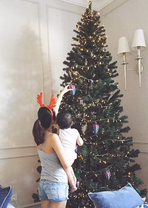 Trước đó, khi cùng con trai trang trí cây thông Noel, Hà Tăng để lộ thân hình đầy dặn trong trang phục áo hai dây ôm dáng và quần jeans. (Ảnh: Instagram nhân vật) 