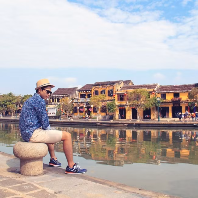 Từ giữa dòng sông Hoài, nhìn sang đôi bên bờ là đường Bạch Đằng với những dãy nhà tường vôi vàng, mái ngói nâu, bên kia là đường Nguyễn Phúc Chu - mặt tiền của khu đô thị mới nhưng vẫn giữ phong cách kiến trúc bản sắc của Hội An.
