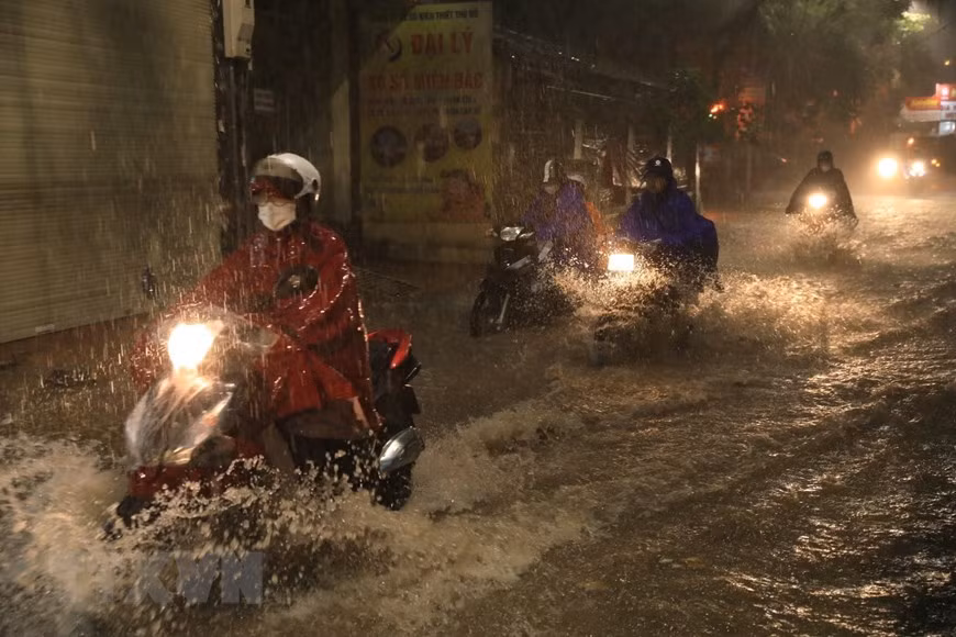 Phố Khương Hạ ngập khiến nhiều người đi lại khó khăn. (Ảnh: Tuấn Anh/TTXVN)