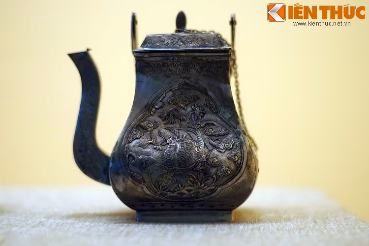 Cận cảnh chiếc ấm. Một mặt ấm khắc hình rùa ngậm cành hoa sen.