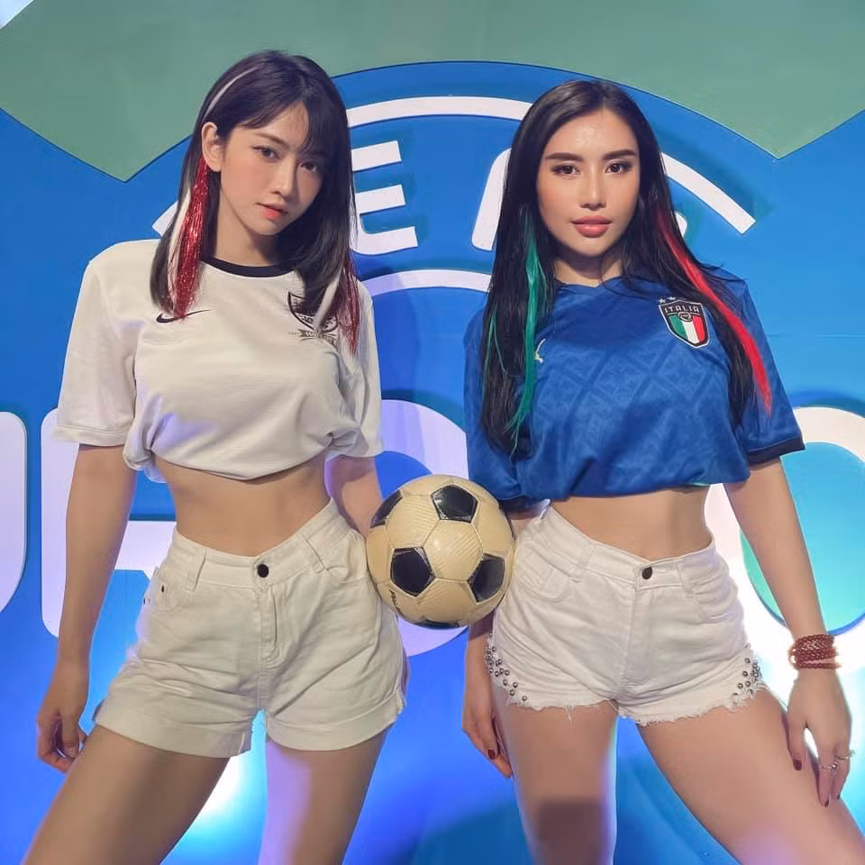 Lê Bống và Trang Tracy đều diện chiếc áo đội tuyển và vén ngắn lên, đồng thời cả hai mặc quần trắng bó sát phía dưới lộ rõ vòng 3 gợi cảm.