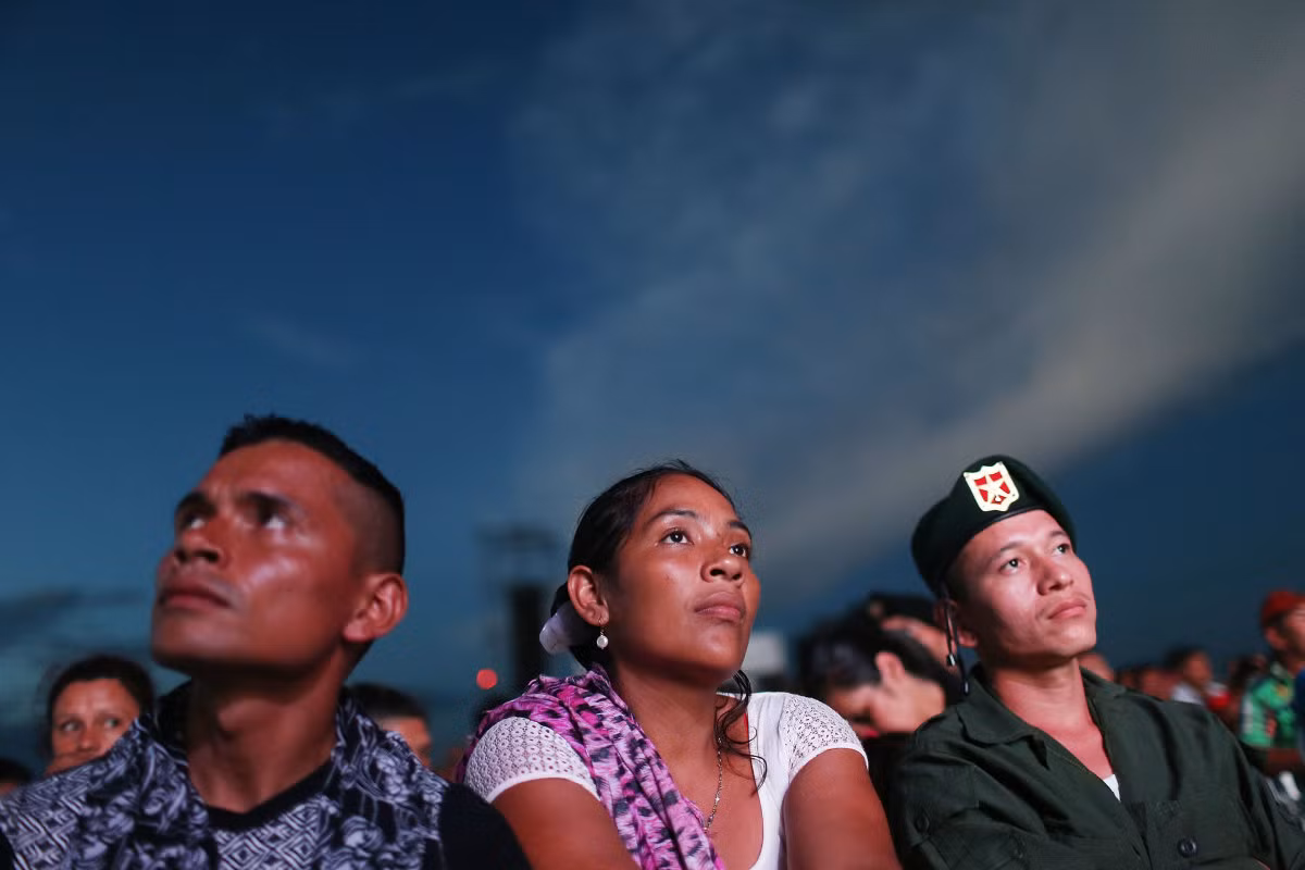 Các thành viên FARC theo dõi buổi phát sóng trực tiếp lễ ký kết thỏa thuận ngừng bắn với chính phủ tại đại bản doanh của họ ở vùng đồng bằng Yari xa xôi. Ảnh USN