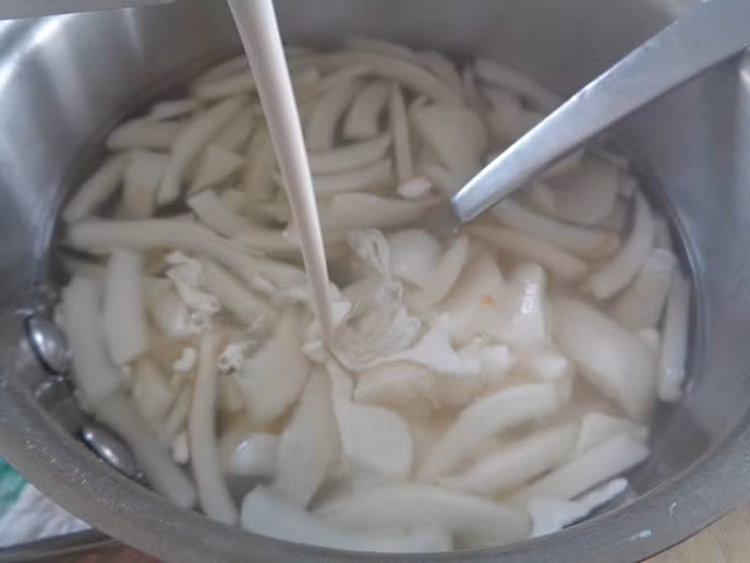 Bước 3: Cho khoảng 700ml nước vào nồi nấu sôi. Thêm bột báng (loại bột giống bột năng dùng để nấu chè) vào nấu khoảng 7 phút thì cho nước cốt dừa, 300 ml nước, đường, dừa non và chút xíu muối vào nồi đun thêm 5-7 phút rồi tắt bếp.
