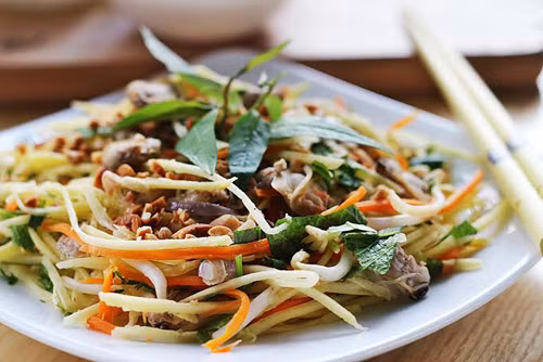 Sau khi mọi hương vị đã hài hoa bạn cho nốt lạc rang giã dập cùng rau húng chó và mùi tàu thái nhỏ vào trộn đều là xong.