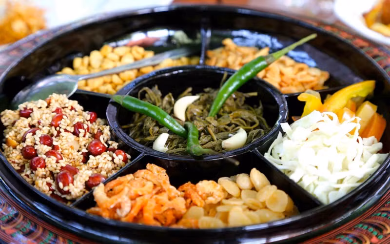 Salad lá trà: Một trong những món ăn ngon ở Myanmar nổi tiếng tiếp theo là món salad lá trà muối. Các lá trà muối có vị chua chua, đắng đắng được trộn cùng với bắp cải thái sợi và cà chua, đậu rán giòn cùng với các loại hạt còn có chút dầu tỏi, ớt, tỏi tươi thái lát. Món này có thể dùng để ăn vặt, khai vị hoặc ăn cùng với cơm như một món chính.