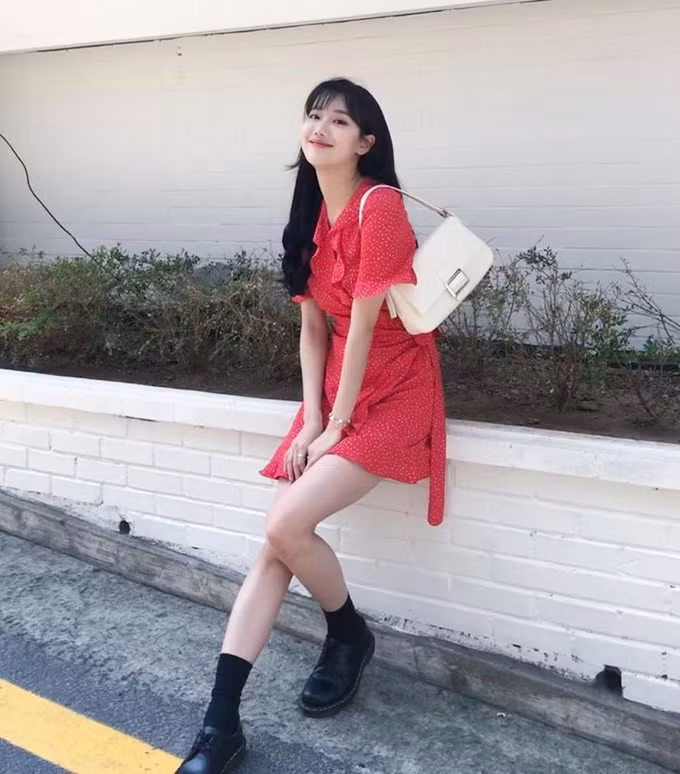 Là một tín đồ phong cách vintage chính hiệu, Na Eun nổi bật trên phố với váy đỏ hoa nhí buộc dây ngang eo đi kèm túi "kẹp nách" và tất cao cổ cá tính. Ảnh: Internet.