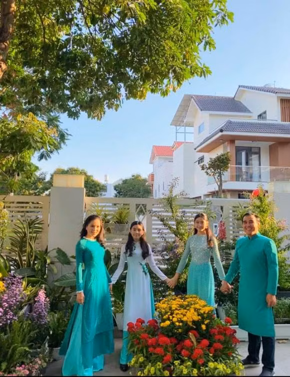 Vợ chồng Quyền Linh và hai cô con gái mặc áo dài xanh tông xuyệt tông vào ngày 1 Tết.