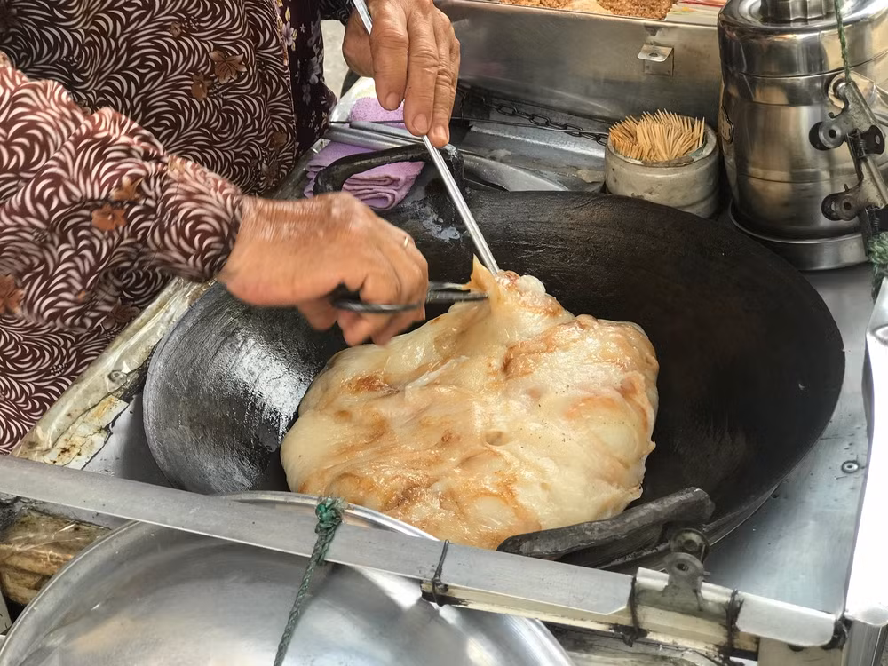 Sau đó, người bán sẽ kéo lên và cắt thành từng viên nhỏ. Lăn qua đậu phộng hay mè đen là có thể thưởng thức ngay. Khi cho vào miệng, lớp vỏ cháy xém giòn giòn kết hợp ăn ý cùng bột dẻo bên trong lạ vị.