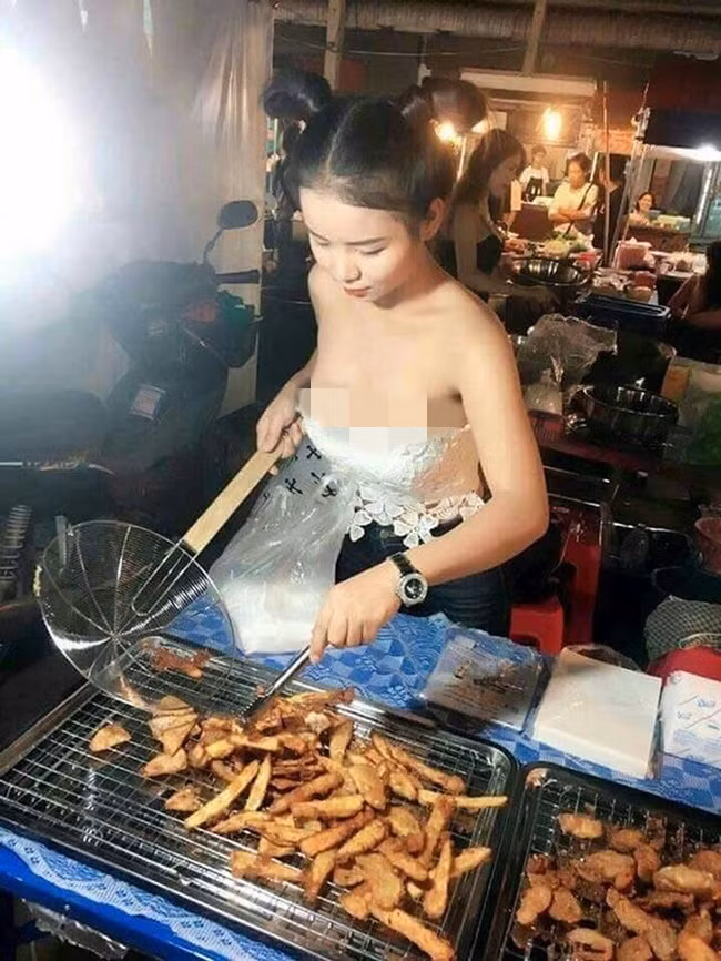 Cô gái mặc chiếc áo quây o ép vòng một và quần ngắn đứng bán đồ ăn đêm gây tranh cãi ở khu chợ Thái Lan.