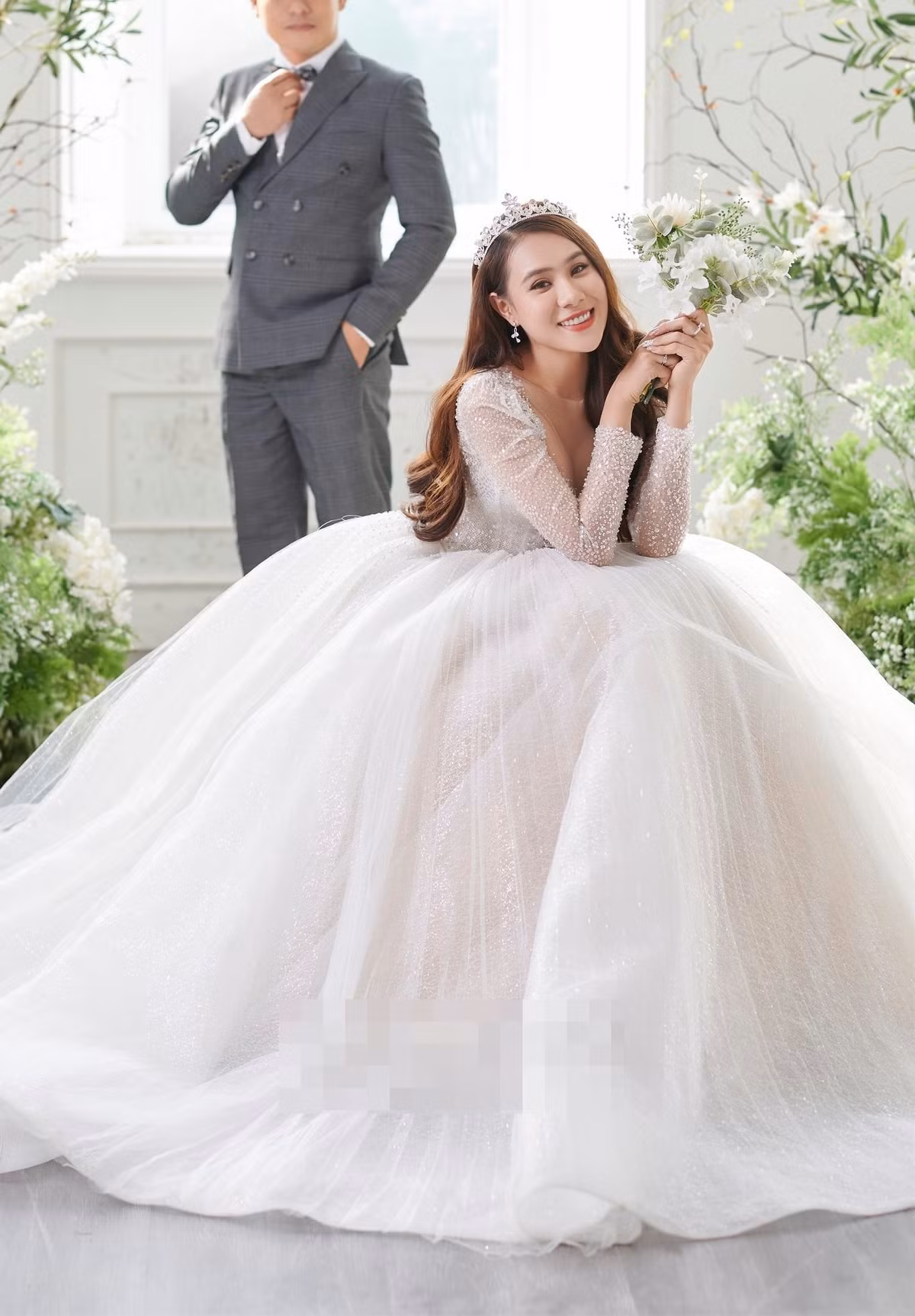 Hồ Bích Trâm diện mẫu váy cưới bồng xòe, đính 4.000 viên đá pha lê và đội vương miện. Trong bộ ảnh cưới, nữ diễn viên giấu kín danh tính và khuôn mặt của chồng. Chia sẻ với Zing, cô cho biết: "Ông xã là người hiền lành, không thích ồn ào hay xuất hiện trên truyền thông. Vì thế, tôi tôn trọng mong muốn của anh".