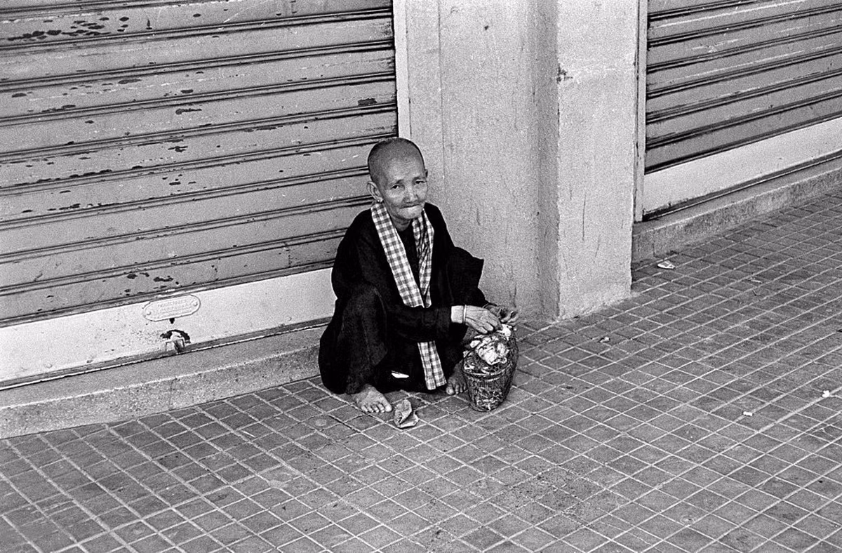 Cụ bà ngồi ở góc vỉa hè. Ảnh: Getty.