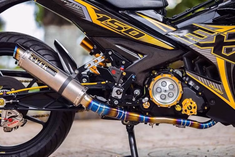Động cơ nguyên bản của Exciter cũng đã được trang trí lại bởi các chi tiết như lốc nồi trong suốt, nắp lọc dầu Bikers, trong khi hệ thống xả được độ lại với cổ pô full system bằng titan và lon pô Over Racing nhập từ Nhật. Ở ngay sau động cơ là pen đạp cho phanh sau cũng là loại "hàng hiệu" Brembo Billet.
