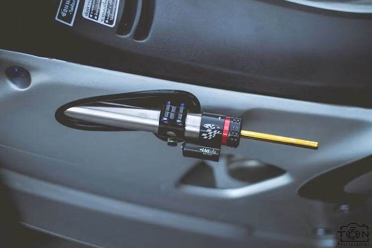 Nằm bên dưới yếm xe là cây trợ lực Matris giúp chiếc Wave ổn định hơn ở tốc độ cao. Toàn bộ dàn nhựa bóng của chiếc xe đã được sơn lại trong gam màu xám bạc ánh kim "lung linh" hơn. Đây là một màu sắc khá hiếm trên những chiếc Wave Thái Lan.