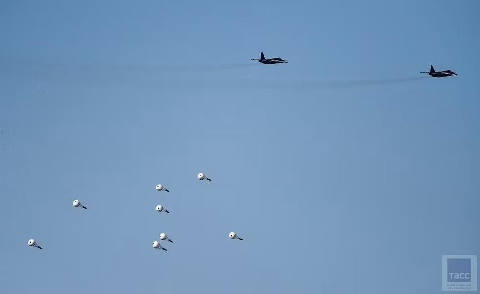 Trong ảnh, biên đội cường kích Su-25 ném bom chùm KMGU – mỗi quả bom đều được gắn dù hãm thả ở độ cao thấp. Nguồn ảnh: TASS