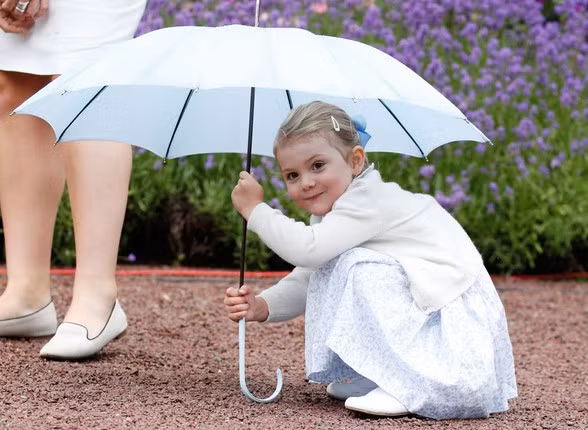 Công chúa Estelle tinh nghịch ngồi dưới một chiếc ô để chụp ảnh ngày 14/7/2015. Ảnh: IT.