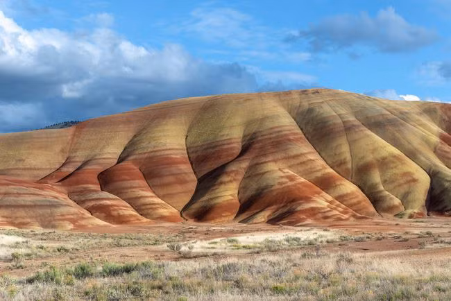 Painted Hills là những ngọn đồi nhẵn, nhiều màu sắc được tạo thành từ tro núi lửa, có niên đại 40 triệu. Các lớp màu đỏ máu nổi bật là do các dải đá ong, một loại đất giàu sắt và nhôm. Nguồn: AlbertoLoyo/Getty.
