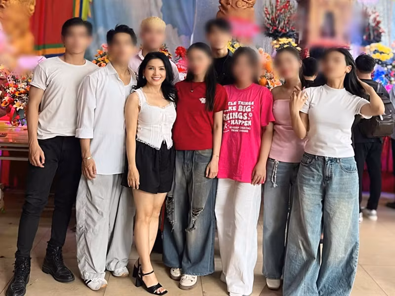 Nữ diễn viên ăn mặc trẻ trung bên các học trò.