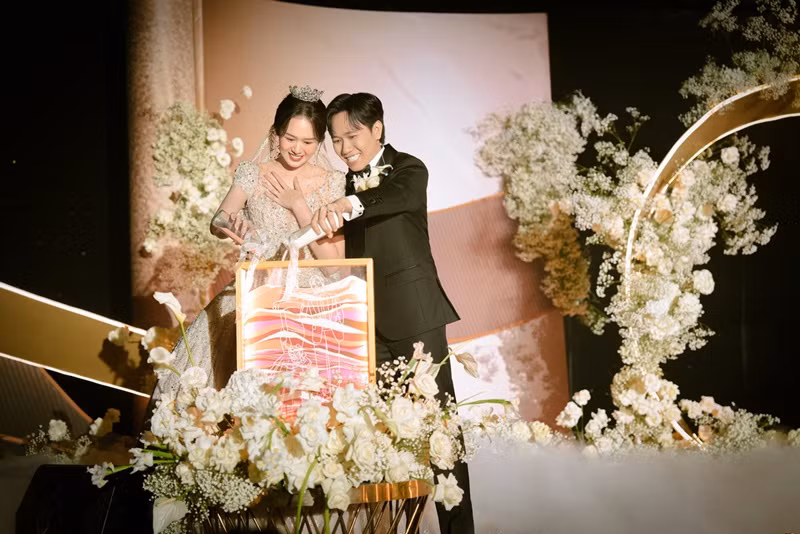 Theo Tiền Phong, vợ chồng Anh Đức thực hiện nghi thức rót rượu cát vào chiếc hộp trong suốt. Đây được xem là biểu tượng cho cam kết mới của cặp đôi, chứa đựng ý nghĩa về sự kết hợp không thể tách rời. Ảnh: Vietnamnet.