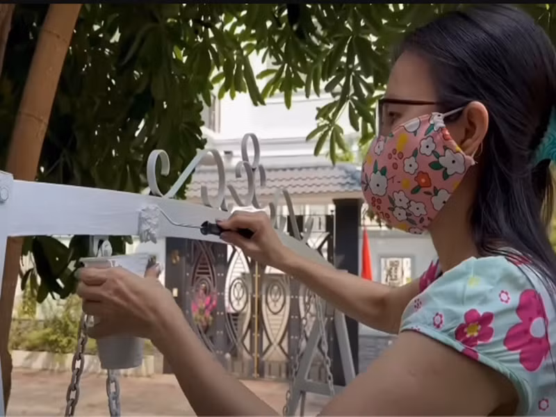 Nữ ca sĩ tự tay sơn lại chiếc xích đu ngoài sân. Ảnh: Youtube Cẩm Ly.