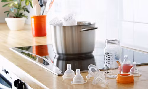  Cho bình sữa và vòng giữ núm, nắp đậy vào nồi nước lạnh và đun sôi. Tiếp đến cho núm ty vào. Sau khi luộc nên lấy bình sữa và các bộ phận khác ra ngay, và úp trên giá cho khô ráo. 