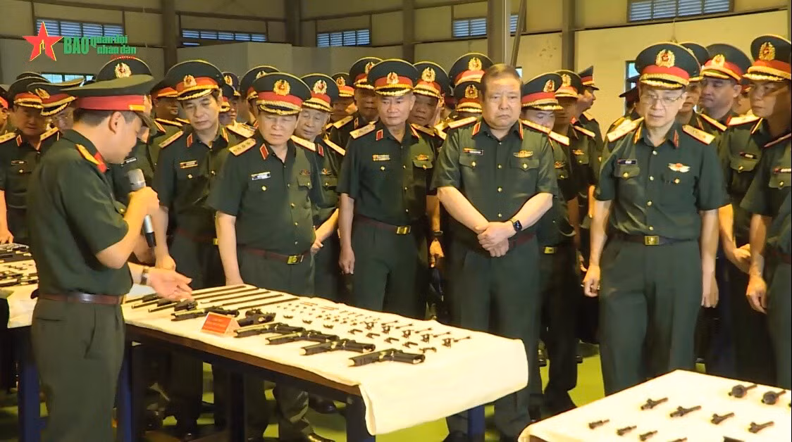 Qua Hội nghị, Tổng cục Công nghiệp Quốc phòng đã giới thiệu cho các cán bộ của Bộ Quốc phòng về rất nhiều loại trang thiết bị, khí tài, vũ khí Việt Nam tự chế tạo. Trong đó, đặc biệt nổi bật và thu hút sự chú ý đó là các mẫu súng mới cực kỳ hiện đại, mẫu mã bắt mắt, tính tùy biến cao và thông số kỹ thuật vượt trội. Ảnh: Cán bộ Tổng cục giới thiệu chi tiết về loại súng ngắn Jericho 941 mới cho đoàn đại biểu.