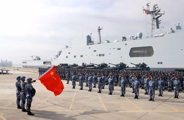 Hải quân giải phóng Trung Quốc hiện nay có đủ khả năng để triển khai đến mọi vùng biển trên địa cầu và đã hình thành được hai cụm tác chiến tàu sân bay. Cuối những năm 1990, đứng trước yêu cầu chuyển mình trở thành hải quân tầm xa, thông tin tình báo là một thứ vô cùng quan trọng trong khi hải quân Trung Quốc lại thiếu loại tàu trinh sát điện tử tầm xa có trọng tải lớn… Ảnh: Lực lượng hải quân đánh bộ Trung Quốc bên cạnh chiếc tàu đổ bộ lớp Type 071.