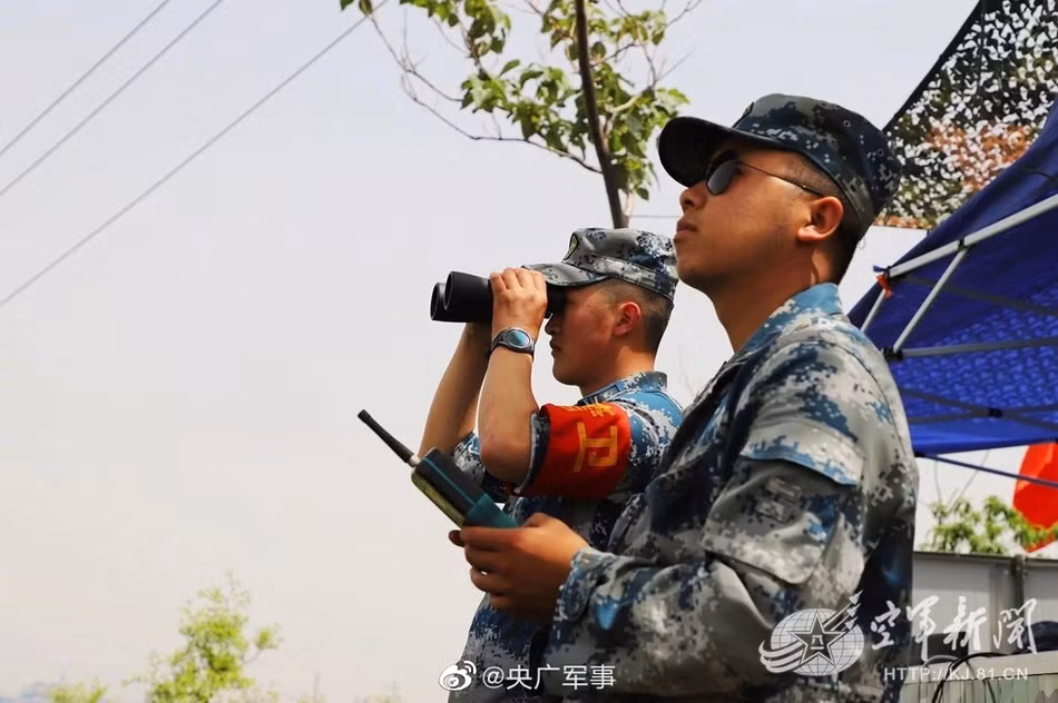 J-7 Chengdu là một loại tiêm kích đánh chặn hạng nhẹ một động cơ, có chiều dài 14.88m, sải cánh 8.32m, trọng lượng cất cánh tối đa 9.100kg. Máy bay sử dụng động cơ Liyang Wopen-13F là phiên bản Trung Quốc chế tạo của động cơ R-13-300 Liên Xô, cho phép nó có thể đạt vận tốc tối đa 2.120km/h, phạm vi chiến đấu 850km và trần bay tối đa 17.800m. Ảnh: Binh sĩ quan sát và theo dõi quá trình máy bay cất cánh. Nguồn: Sina.
