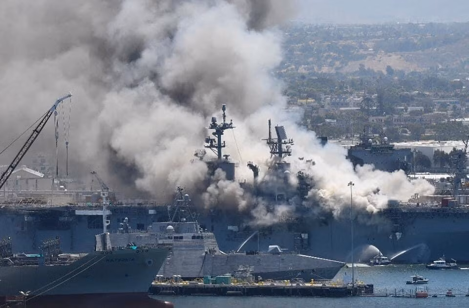 Theo ghi nhận, ngọn lửa bốc lên từ tàu đổ bộ USS Bonhomme Richard (LHD-6) được nhìn thấy và báo cáo cho cơ quan chức năng lúc 8h30 sáng ngày 12/7 (Giờ địa phương). Con tàu sau đó đã bốc cháy rất dữ dội và lửa đã lan ra nhanh chóng. Lúc này trong quân cảng San Diego nơi con tàu neo đậu cũng đang có rất nhiều tàu của hải quân Hoa Kỳ khác. Ảnh: Tàu cứu hộ đang cố phun vòi rồng chữa cháy cho tàu USS Bonhomme Richard (LHD-6).