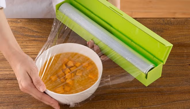 Các thành phần hóa học trong màng bọc sẽ ngấm vào thức ăn, gây ra các phản ứng hóa học rồi tác hại xấu đến sức khỏe của người dùng. (Ảnh Vietpat)