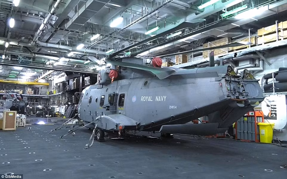 HMS Ocean có khả năng chuyên chở 40 xe tải, 830 lính thủy đánh bộ và tối đa 18 trực thăng hạng trung/hạng nặng. Trong ảnh, một chiếc trực thăng vận tải hạng trung Merlin trong khoang bảo dưỡng. Nguồn ảnh: Dailymail.
