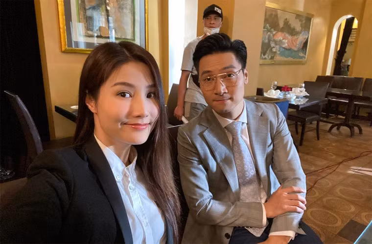 Diễm My và Mạnh Trường mặc áo vest chỉnh tề chuẩn bị cho một cảnh quay khi đóng phim giữa mùa hè.