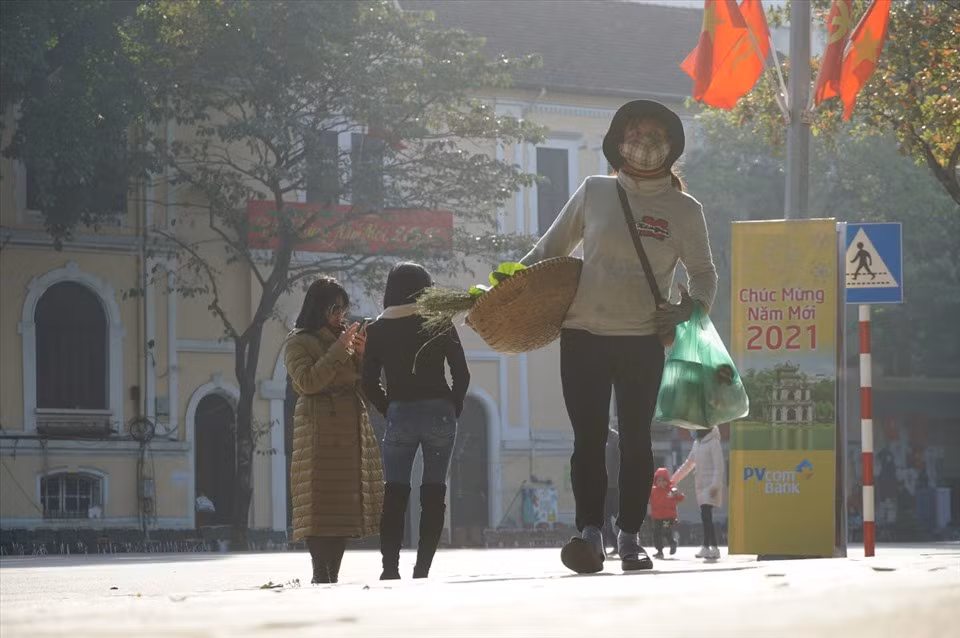 Trong khi người dân tấp nập đi chơi tết, người phụ nữ bán cốm miệt mài đi khắp ngõ ngách để bán chút hàng.