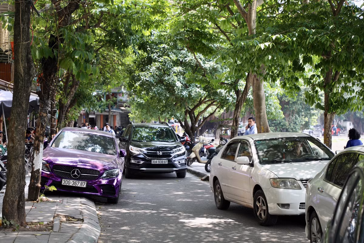 Ô tô đỗ 2 bên vỉa hè, tràn xuống lòng đường khiến giao thông tại đây di chuyển khó khăn.