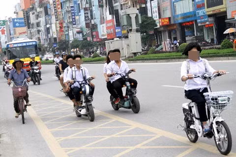 Không chỉ "hiên ngang" không đội mũ bảo hiểm khi điều khiển xe máy điện, các bạn sinh học còn túm năm, tụm ba, dàn hàng ngang trên các con phố, khiến việc di chuyển của những người xung quanh rất khó khăn.