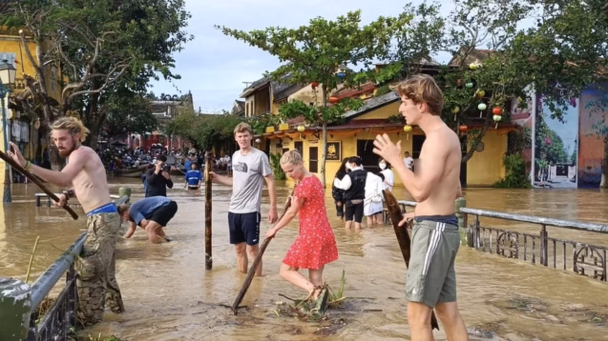 Trong lúc người dân Hội An vẫn đang khắc phục hậu quả sau bão, hàng trăm khách du lịch trong và ngoài nước đã hồ hởi trở lại tham quan, trải nghiệm cảnh nước lũ tràn về Hội An. Ảnh: PhunuVietNam