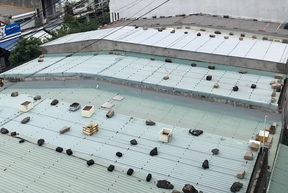 Trên các mái nhà xuất hiện những bao tải cát, gạch, đá, sỏi... hoặc những vật nặng để chặn cho mái tôn khỏi bay.