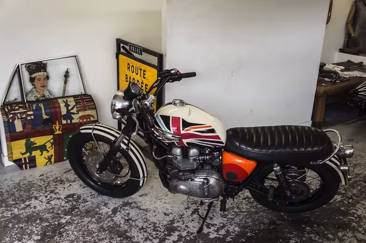 Ghi-động lớn, màu đen theo phong cách xe đua flat-track tại Mỹ đã được thay cho ghi-đông nguyên bản của Scrambler Paul Smith. Do có ghi-đông mới nên giá gắn đồng hồ nguyên bản của xe cũng phải được thay đổi lại cho phù hợp.