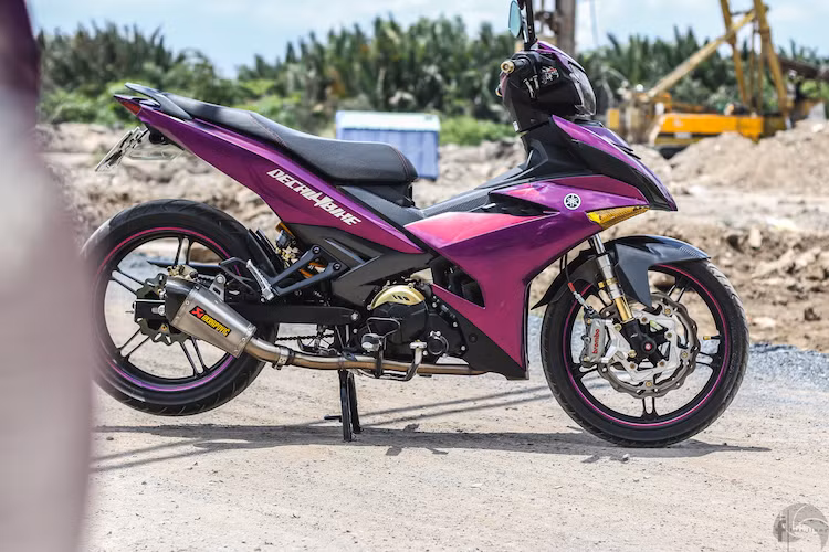 Tuy nhiên, một số người chơi xe khác, chẳng hạn như chủ nhân của chiếc Exciter này lại hướng tới việc "độ kiểng" nhẹ nhàng cho chiếc xe thay vì thay đổi tới kết cấu. Trong đó, chi tiết đơn giản nhất đó là toàn bộ vỏ xe đã được chủ xe dán lại bằng decal trong tông màu tím chrome đặc biệt.