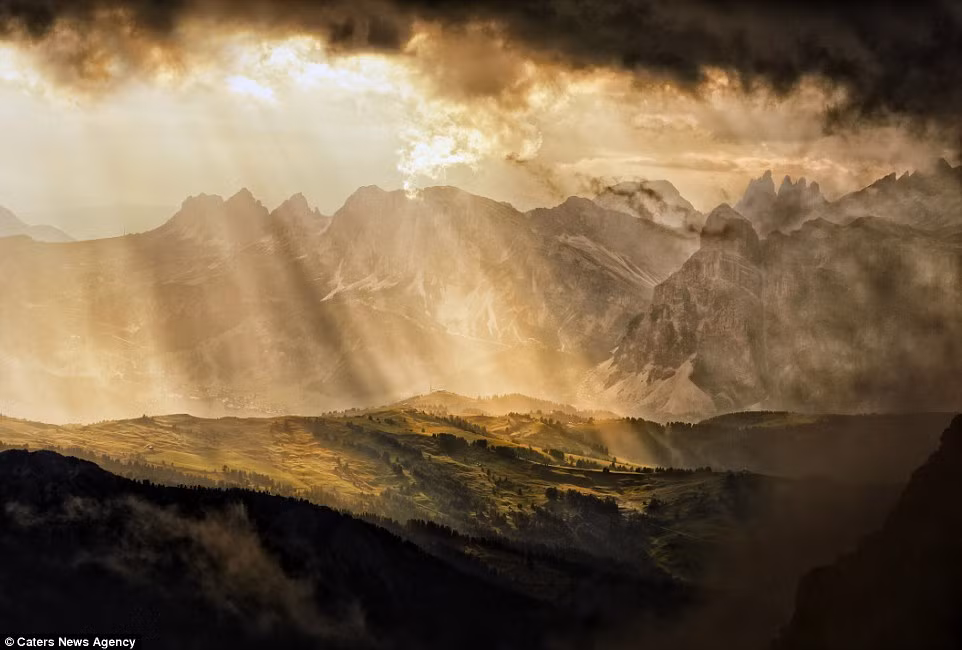 Những tia nắng ban mai chiếu xuống một ngôi làng ở vùng núi Dolomite, Italy.