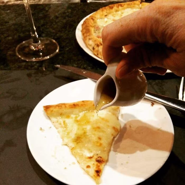 Mật ong được rưới lên pizza phô mai.