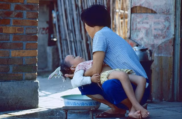 Người mẹ gội đầu cho con. Ảnh chụp ở Quảng Đông những năm 1970.