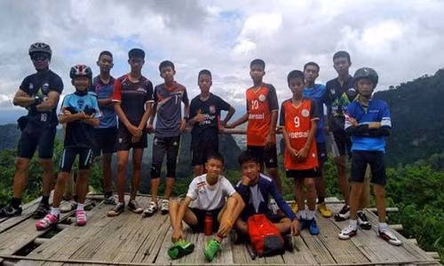 Các thành viên của đội bóng nhí "Lợn rừng" cùng vị huấn luyện viên 25 tuổi.