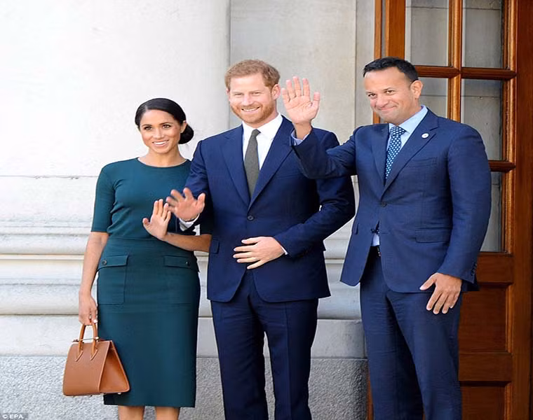 Vợ chồng Hoàng tử Harry vẫy chào trước ống kính trước khi có cuộc hội đàm với Thủ tướng Ireland Leo Varadkar (phải) tại văn phòng của ông trong tòa nhà chính phủ ở thủ đô Dublin.