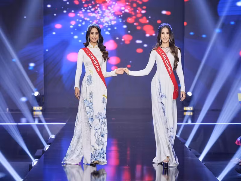 Các thí sinh trình diễn theo cặp ở phần thi trang phục áo dài. Ảnh: Miss Charm