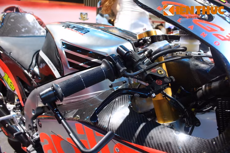 Ở phía trên tay lái tiếp tục là những phụ kiện "hàng hiệu" gồm cùm phanh Brembo và vòng bảo vệ tay Rizoma. Toàn bộ dàn vỏ của RS-GP đã được Aprilia làm từ sợi carbon và chỉ sơn phủ một phần, để lộ những đường vân "đều tăm tắp" đặc trưng của vật liệu này.