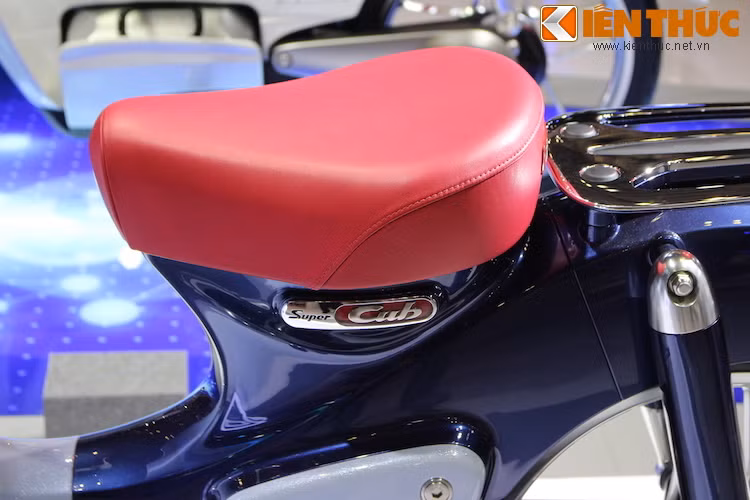 Chiếc xe vẫn giữ nguyên bộ yên đơn và giá đèo hàng giống như truyền thống của Super Cub. Bên dưới yên xe là logo Super Cub được thiết kế đẹp mắt với các mảng sơn đỏ trên nền mạ chrome.