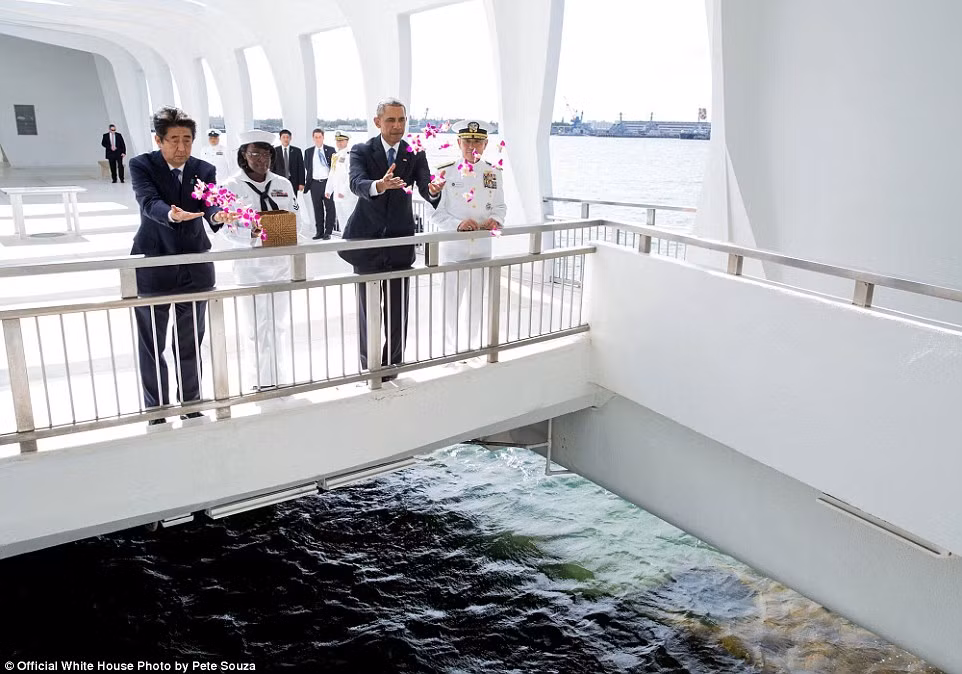Tổng thống Obama cùng Thủ tướng Nhật Bản Shinzo Abe thả hoa xuống trong lần tới Đài tưởng niệm USS Arizona ở Trân Châu cảng ngày 27/12. Ảnh Daily Mail