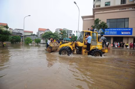Khoảng chục người một lượt vận chuyển qua chỗ ngập để có thể "thoát thân". Ảnh: Dân Việt.
